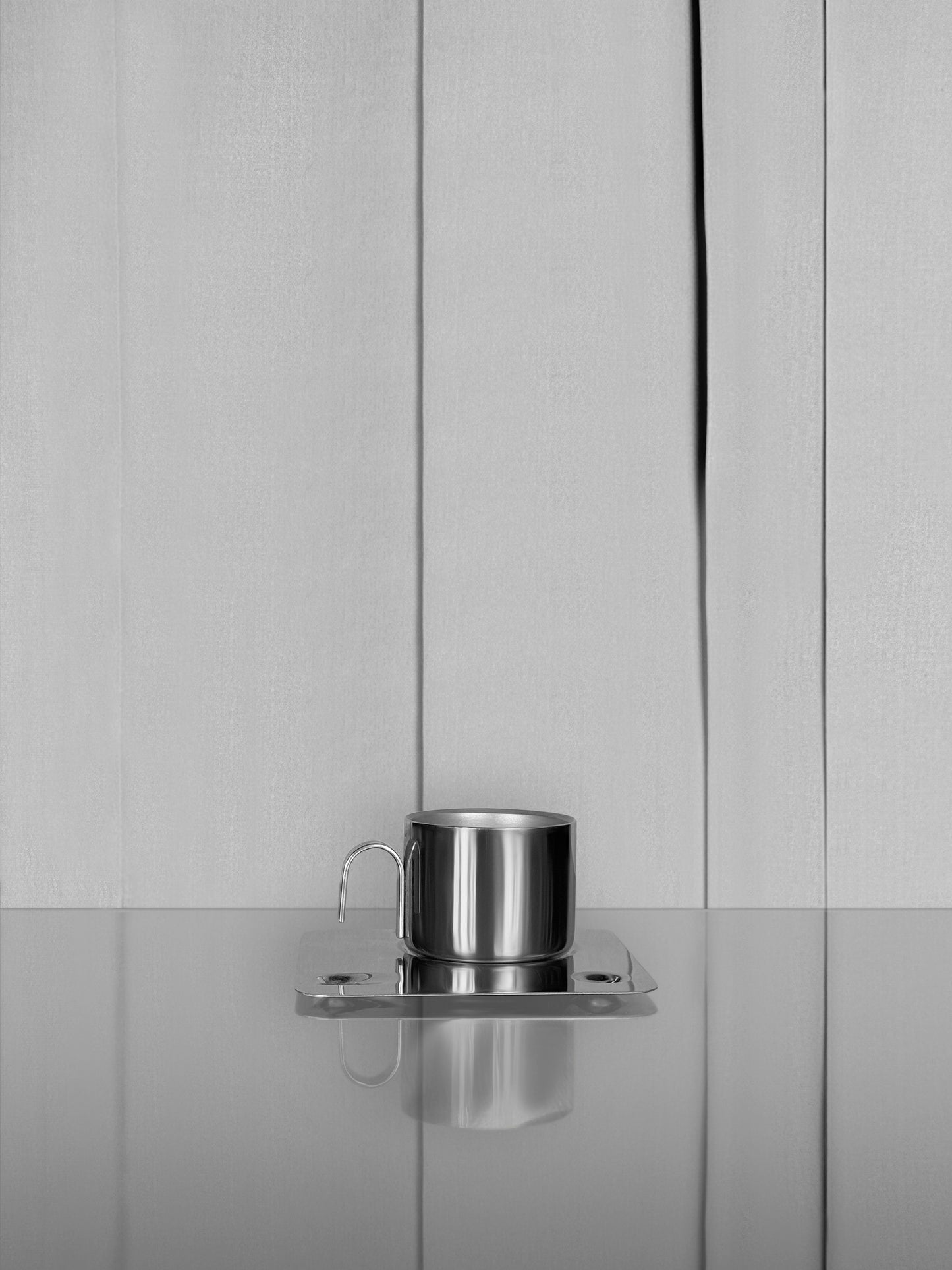 Coffee in a steel cup on a geometric tray